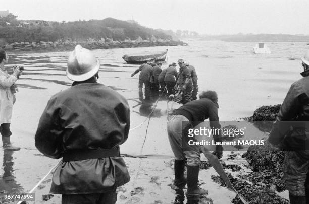 Pompiers et bénévoles lors du nettoyage de la plage après le naufrage du pétrolier Amoco Cadiz le 21 mars 1978 à Portsall, France.