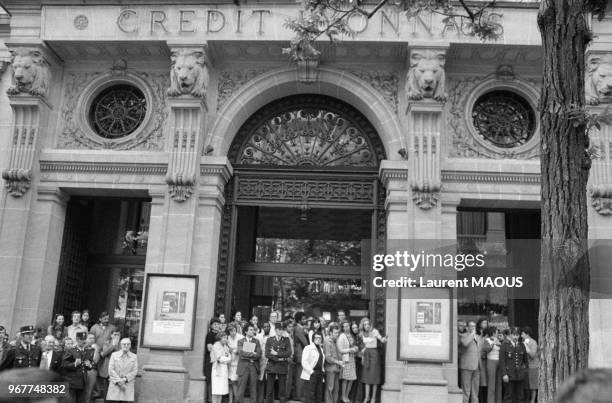 Les personnels de l'établissement bancaire réunis devant l'immeuble peu après l'assassinat du PDG Jacques Chaine le 14 mai 1976 à Paris, France.