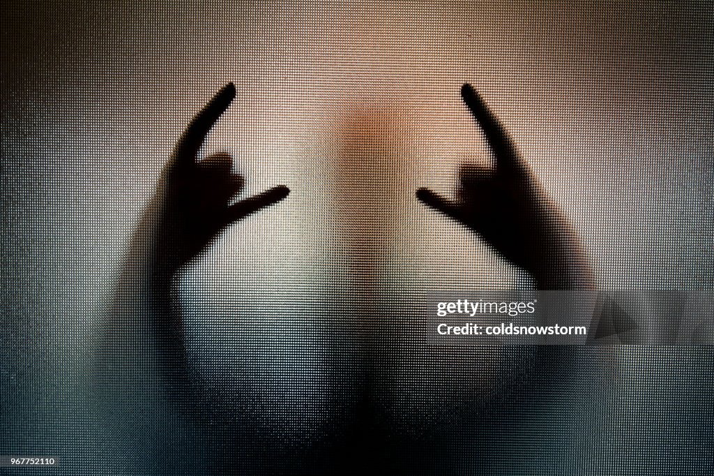 Silhouette of heavy metal horn sign hand gesture