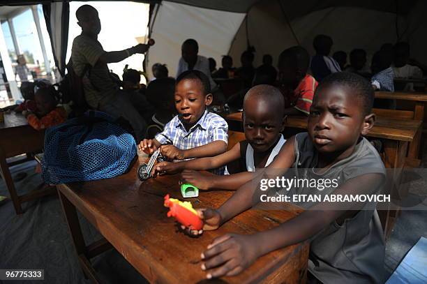 Haitian children receive a lesson inside a tent at the courtyard of a religious school in the heart of Petion-ville, in the heights of the Haitian...