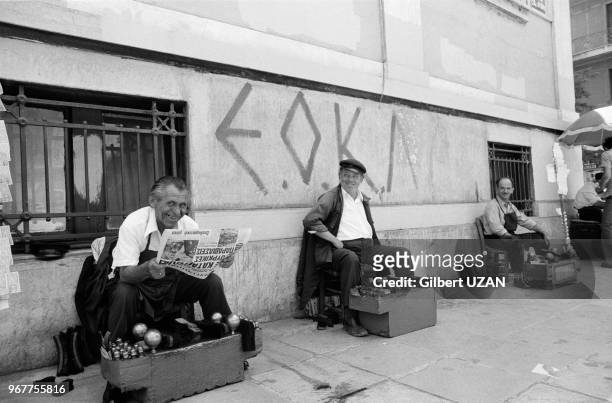Cireurs de chaussures dans les rues d'Athènes après le chute du régime des colonels le 24 juillet 1974,Grèce.