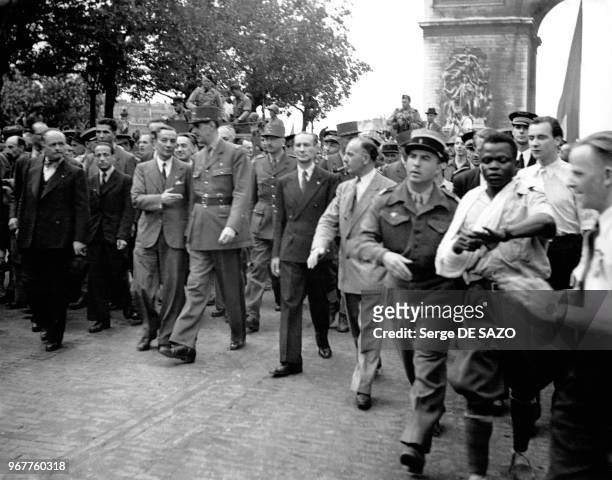 Descente Des Champs Élysées par le général Charles de Gaulle, entouré de Georges Bidault et d'Alexandre Parodi , suivis de membres du GPRF, de...
