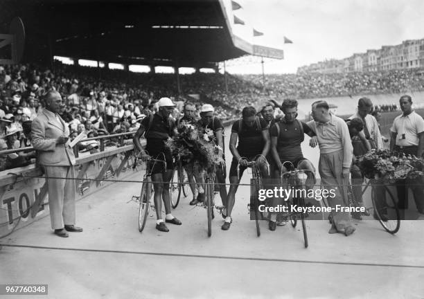 équipe belge après son arrivée, à gauche, tenant un bouquet de fleurs, Sylvère Maes, frère du vainqueur, le quatrième en partant de la gauche est...