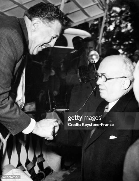 Acteur Michel Simon serre la main du président Vincent Auriol venu le saluer sur son stand de la 6ème kermesse aux Etoiles organisée au profit des...