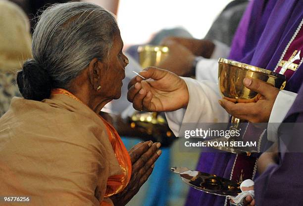 An Indian Catholic Christian receives The Holy Eucharist during an Ash Wednesday service at Saint Mary's Church in Secunderabad on February 17, 2010....