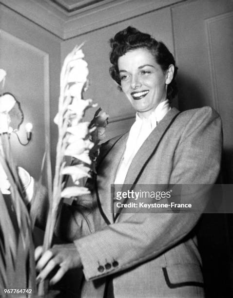 Actrice américaine Jane Russell met des glaïeuls, ses fleurs préférées, dans un vase à son arrivée dans un hôtel de luxe des Champs-Elysées le 20...