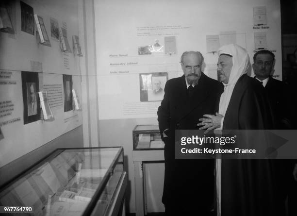 Georges Le Beau, gouverneur d'Algérie visitant une exposition sur l'Algérie littéraire aux côtés du directeur de la Grande Mosquée de Paris, Si...