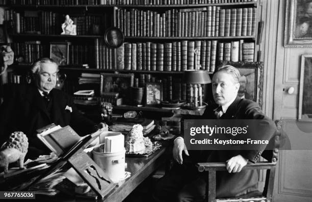 Léo Larguier, nouveau membre de l'académie Goncourt, discutant dans son bureau bibliothèque avec Roland Dorgelès à Paris, France, le 27 mai 1936.