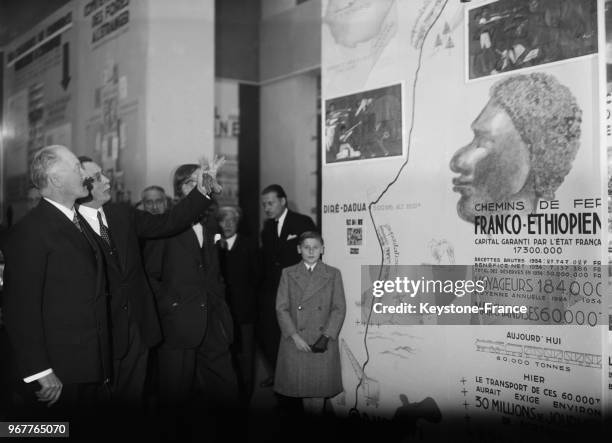 Le Président de la République Albert Lebrun examine un panneau des chemins de fer franco-éthiopien pendant sa visite de l'exposition Galerie...