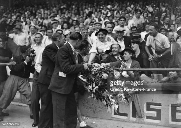 Le vainqueur du Tour, Romain Maes, reçoit des fleurs d'une admiratrice, à Paris, France le 28 juillet 1935.