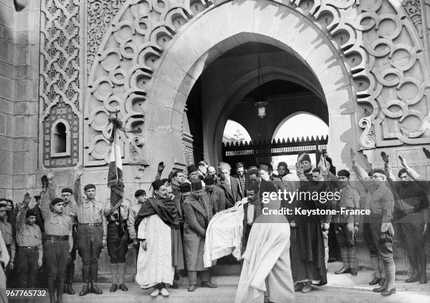 Le corps d'un manifestant musulman, tué dans les bagarres pendant les émeutes, arrive à la mosquée, à droite, au premier plan, Si Kaddour Benghabrit,...