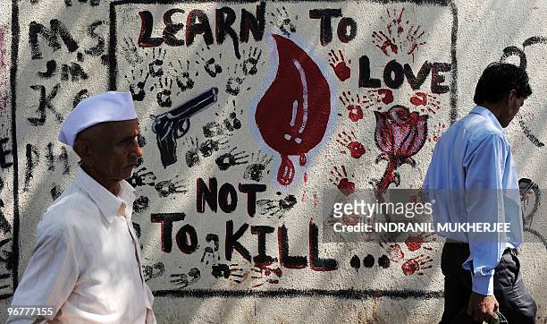 Indian commuters walk past a wall mural in memory of the November 2008 terror attack victims in Mumbai on Feburary 17, 2010. Last week's deadly bomb...