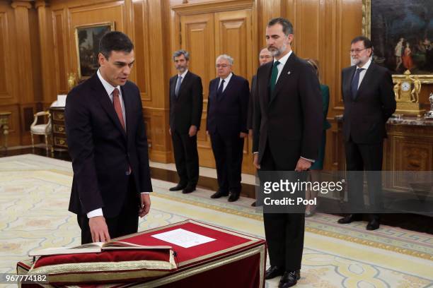 King Felipe VI of Spain looks on as Spain's new Prime Minister Pedro Sanchez takes the oath as President of the Spanish Constitutional Court Juan...