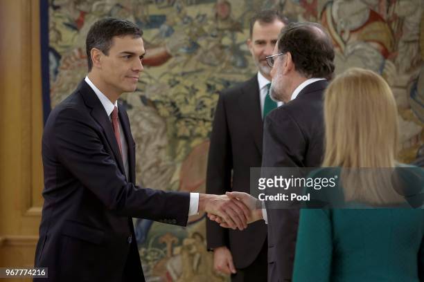 Spain's new Prime Minister Pedro Sanchez shakes hands with Former Prime Minister Mariano Rajoy as King Felipe VI of Spain and President of the...