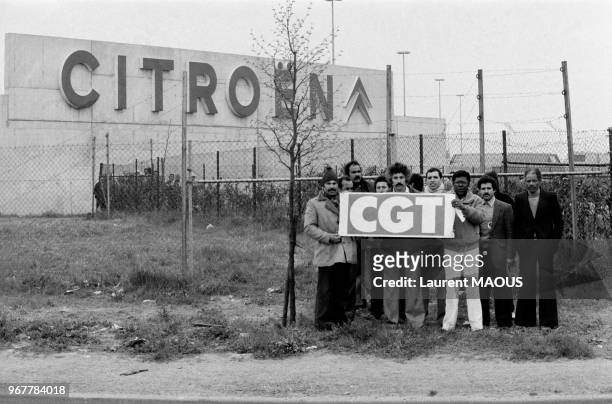 Ouvriers en grève brandissant une pancarte CGT devant l'usine Citroën le 27 avril 1982 à Aulnay-sous-Bois, France.