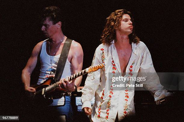 Tim Farriss and Michael Hutchence of INXS perform on stage on the 'Kick' tour at Wembley Arena on June 24th, 1988 in London, United Kingdom.