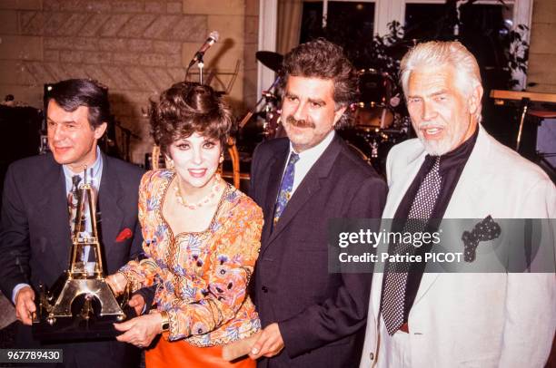 James Coburn, Gina Lollobrigida, Roland Magdane et Adamo lors d'un tournoi de pétanques à Paris le 26 juin 1991, France.