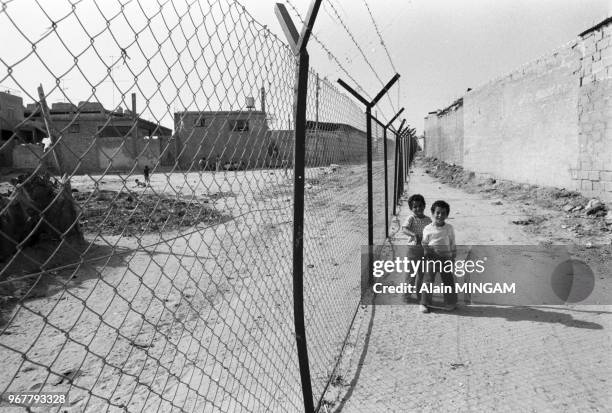 Enfants près de barbelés le long de la frontière lors du départ de l'armée israélienne de Rafah le 25 avril 1982, Palestine.