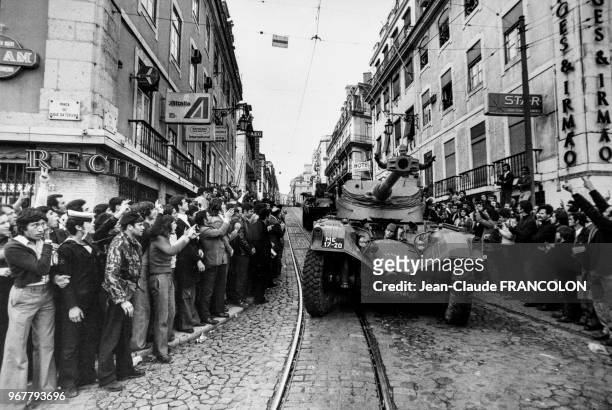 La foule salue des militaires sur leurs blindé dans une rue de Lisbonne lors de la révolution des oeillets le 25 avril 1974, Portugal.