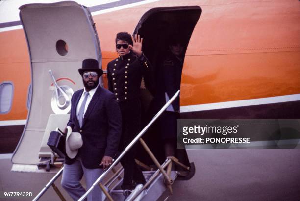 Michael Jakson accompagné de son garde du corps sortant de l'avion à son arrivée à l'aéroport de Montréal le 17 septembre 1984, Canada.