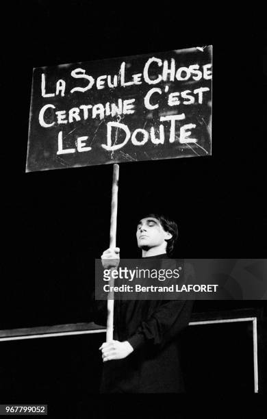 Un homme tient une pancarte où est écrit 'La seule chose certaine c'est le doute' lors d'une réprésentation théâtrale le 20 avril 1983 à Paris,...