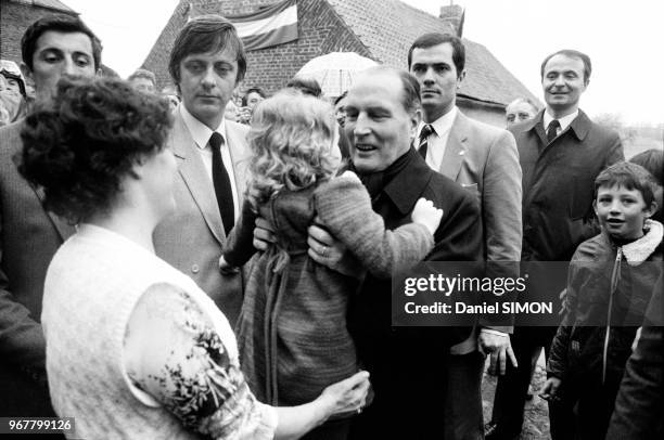 François Mitterrand prend une petite fille dans ses bras lors de son déplacement dans le département du Nord le 26 avril 1983, France.