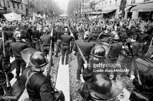 Cordon de gendarmes équipés de leur fusil lance-grenade faisant face à des étudiants manifestant leur opposition au projet de réforme de...