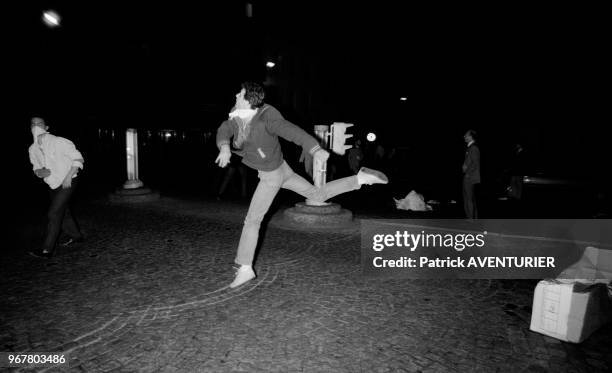 Un manifestant jette des des objets sur les forces de l'ordre lors d'affrontements après la manifestation pour l'école libre à Paris le 23 mai 1984,...