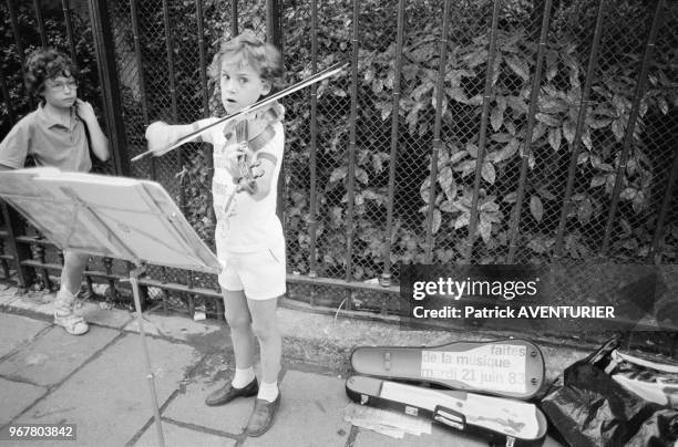 Enfant jouant du violon dans la rue lors de la Fête de la Musique à Paris le 21 juin 1983, France.