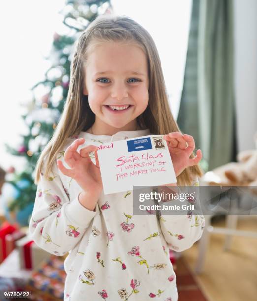 young girl holding letter addressed to santa claus - santa portrait stock-fotos und bilder