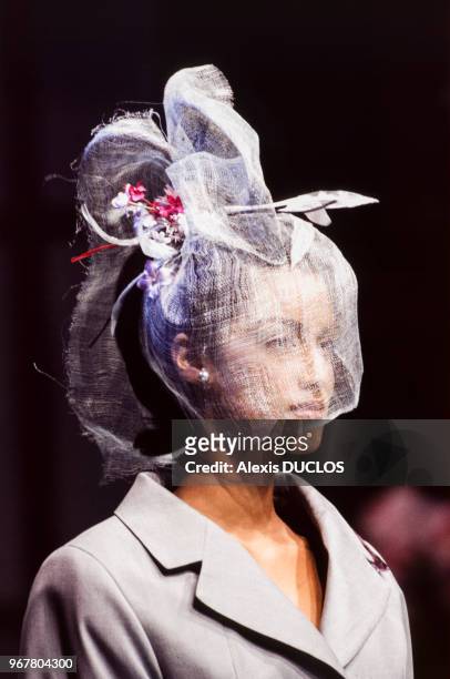 Portrait du mannequin Yasmeen Ghauri portant un chapeau et une voilette recouvrant son visage du couturier Christian Dior lors du défilé de la...