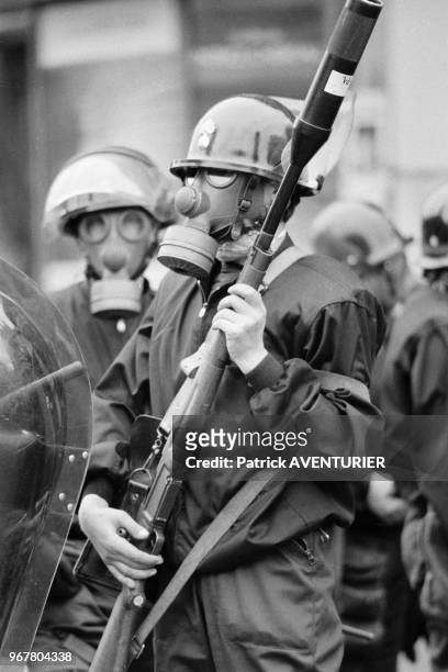 équipé d'un fusil lance grenade lors d'une manifestation contre le projet de réforme de l'enseignement supérieur à Paris le 24 mai 1983, France.