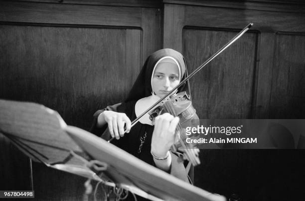 Jeune soeur jouant du violon lors de la venue du Pape Jean-Paul II le 17 mai 1983 à Varsovie, Pologne.