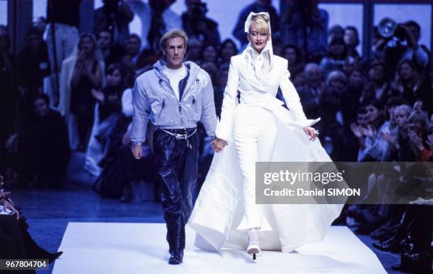 Claude Montana accompagne son mannequin en robe de mariée lors de son défilé, Prêt-à-Porter, collection Printemps-été 1996 à Paris le 14 octobre...