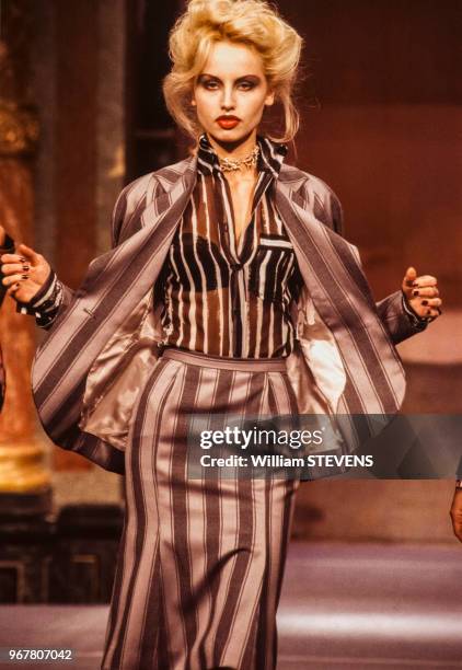Portrait du mannequin Adriana portant un ensemble tailleur-jupe dessiné par la couturière Vivienne Westwood lors du défilé de la collection...