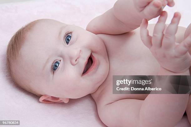 baby with bright blue eyes on pink blanket - baby blue eyes stock pictures, royalty-free photos & images