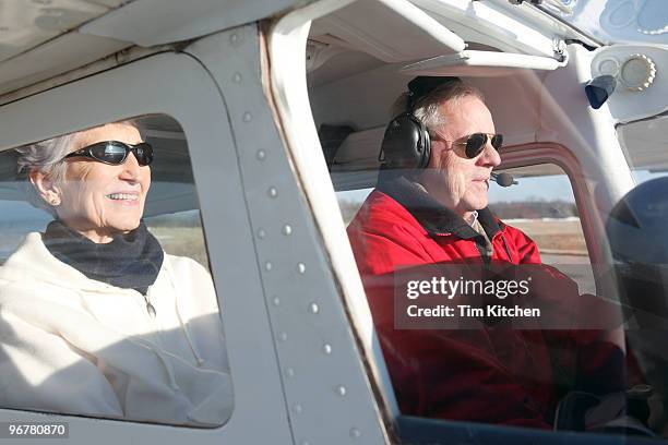 mature couple in airplane on runway - couple airplane stock pictures, royalty-free photos & images
