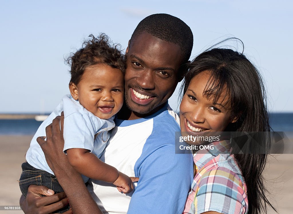 Black couple and baby on the beach