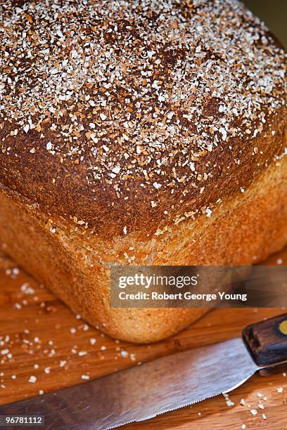 home made bread and bread knife on cutting board - bread knife stock pictures, royalty-free photos & images