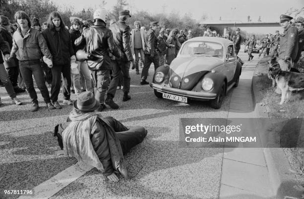 Militant assis devant une voiture de police lors d'une manifestation anti-nucléaire à Bonn le 22 octobre 1983, Allemagne.