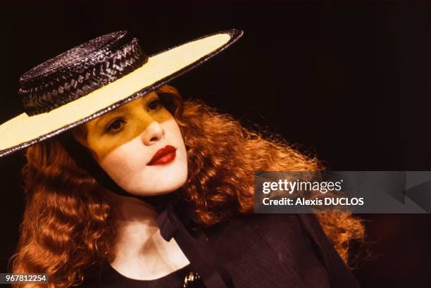 Un mannequin porte un chapeau plat noué sous le menton par un ruban du couturier Yves Saint-Laurent lors du défilé de la collection printemps-été le...