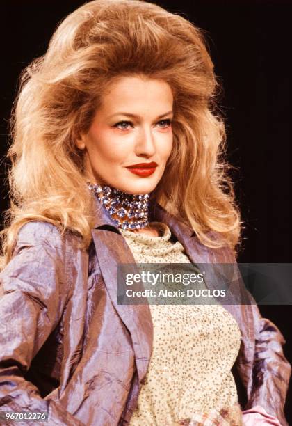 Portrait du top-model Karen Mulder portant une création du couturier Christian Lacroix lors du défilé pour la collection haute-couture automne-hiver...