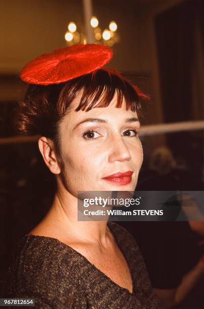 Portrait de la comédienne Clémentine Célarié coiffée d'un petit chapeau plat rouge lors d'un défilé de prêt-à-porter Ocimar Versalato le 18 octobre...