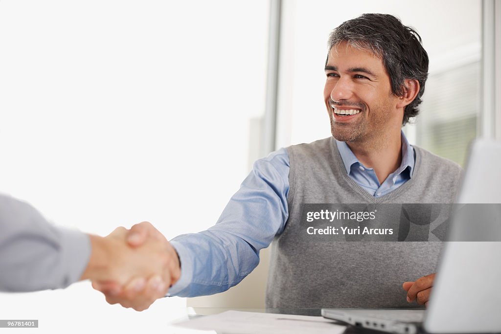 Happy successful business man shaking hands