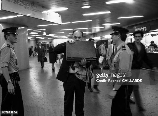 Des policiers contrôlent une personne dans le RER après la série d'attentat qui a touché Paris, le 16 septembre 1986, France.