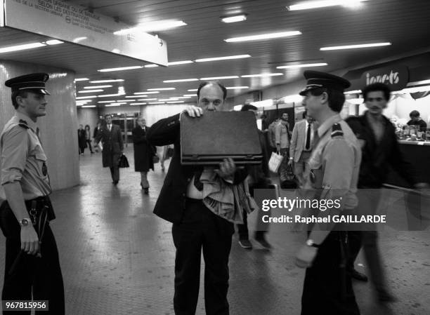 Des policiers contrôlent une personne dans le RER après la série d'attentat qui a touché Paris, le 16 septembre 1986, France.