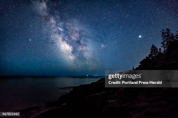 The Milky Way shines above the ocean off the coast of Acadia National Park in the early morning hours of Monday, April 23, 2018. Night skies in...