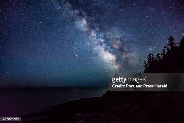 The Milky Way shines above the ocean off the coast of Acadia National Park in the early morning hours of Monday, April 23, 2018. Night skies in...
