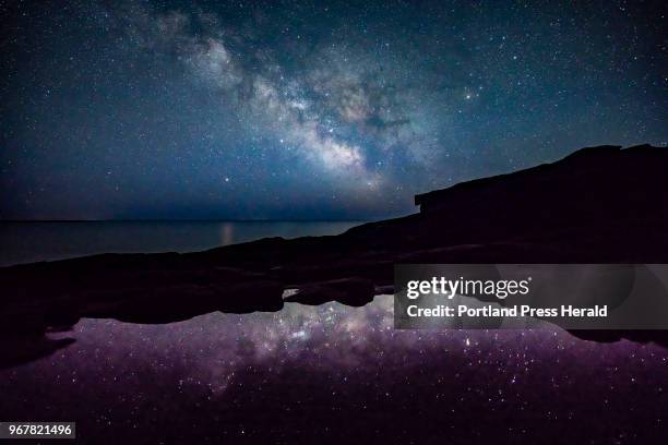 The Milky Way shines above the ocean off the coast of Acadia National Park in the early morning hours of Monday, April 23, 2018. Night skies in...