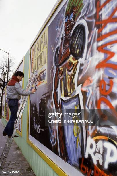 Artiste Daniel Baugeste ou Bau Geste détourne une affiche à Paris le 24 novembre 1984, France.